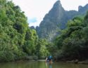 People on a bamboo raft on the water in Khao Sok National Park in Thailand