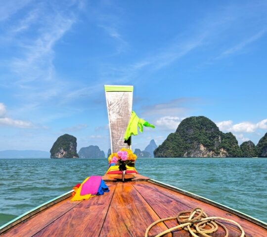 View showing the prow of a traditional longtail boat sailing through the water in Thailand