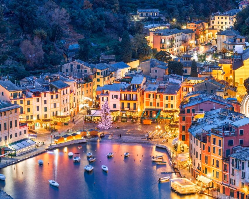 Aerial view of Portofino harbour at dusk with the buildings lit up for the evening