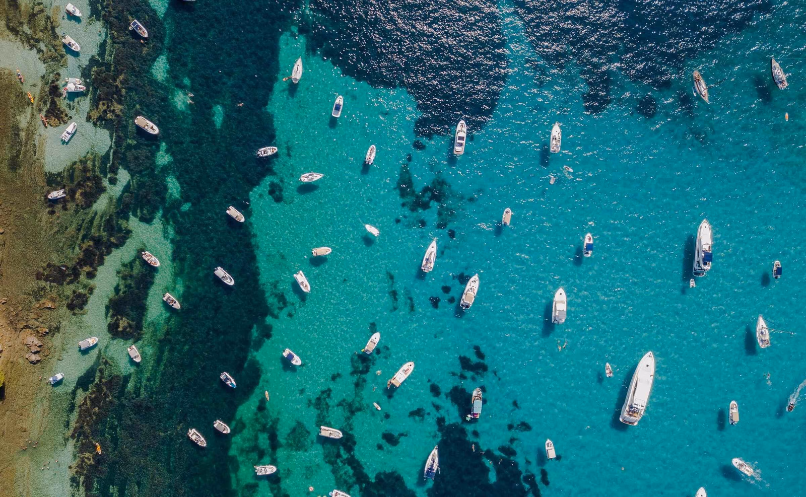 Aerial view of yachts floating in bright blue water on the Cote d'Azur