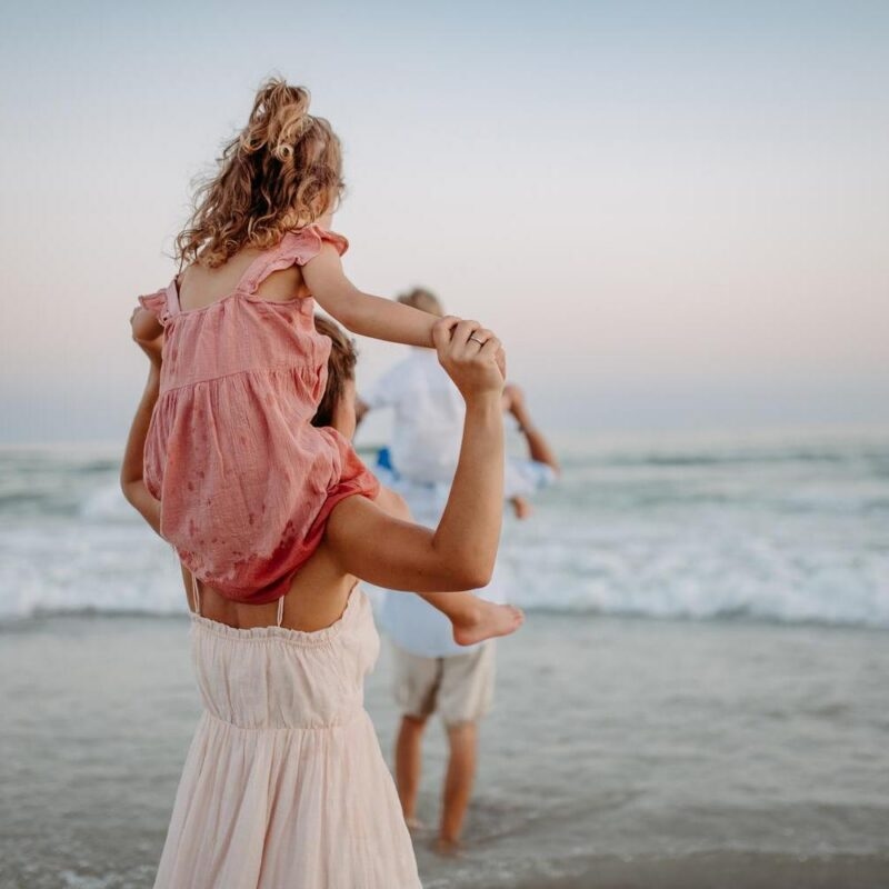 a happy family with young children enjoying the beach