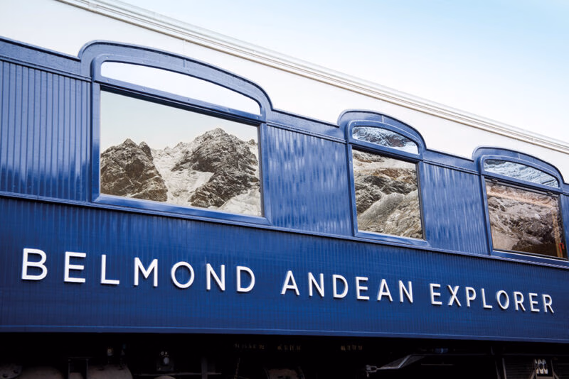 Mountain reflections on the blue exterior of luxury Peru train trips.