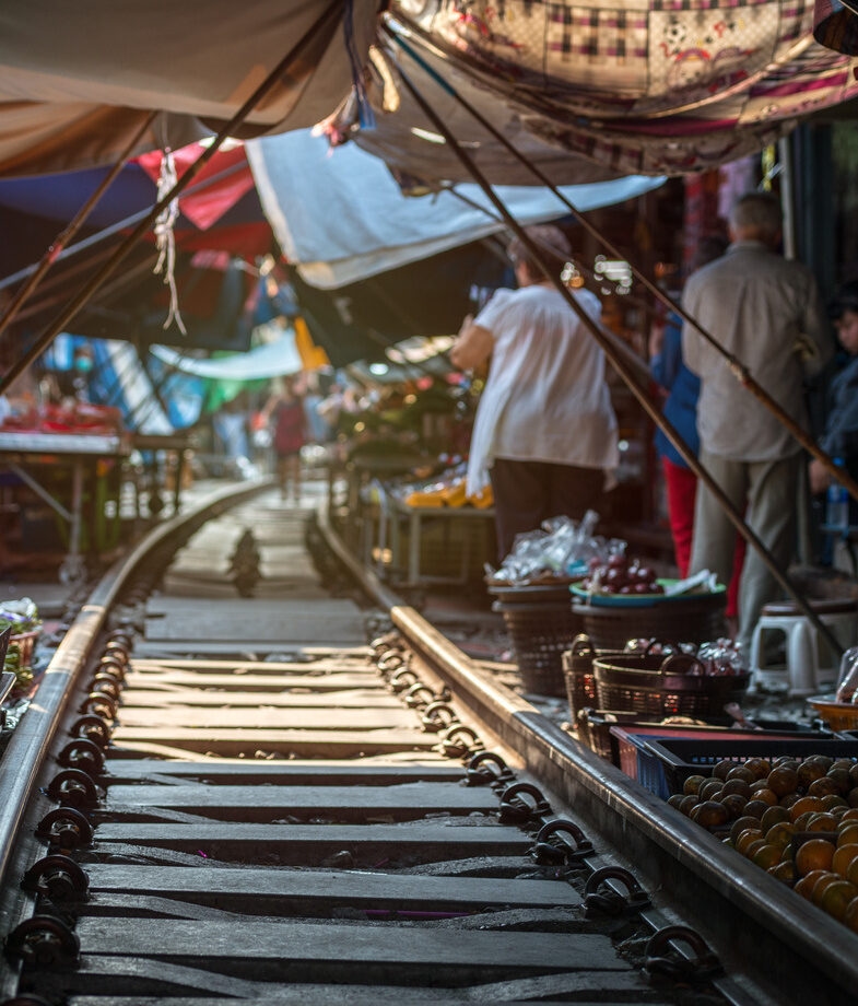 The tracks of Maeklong Railway Market in Thailand and Balinese dancers in traditional dress.