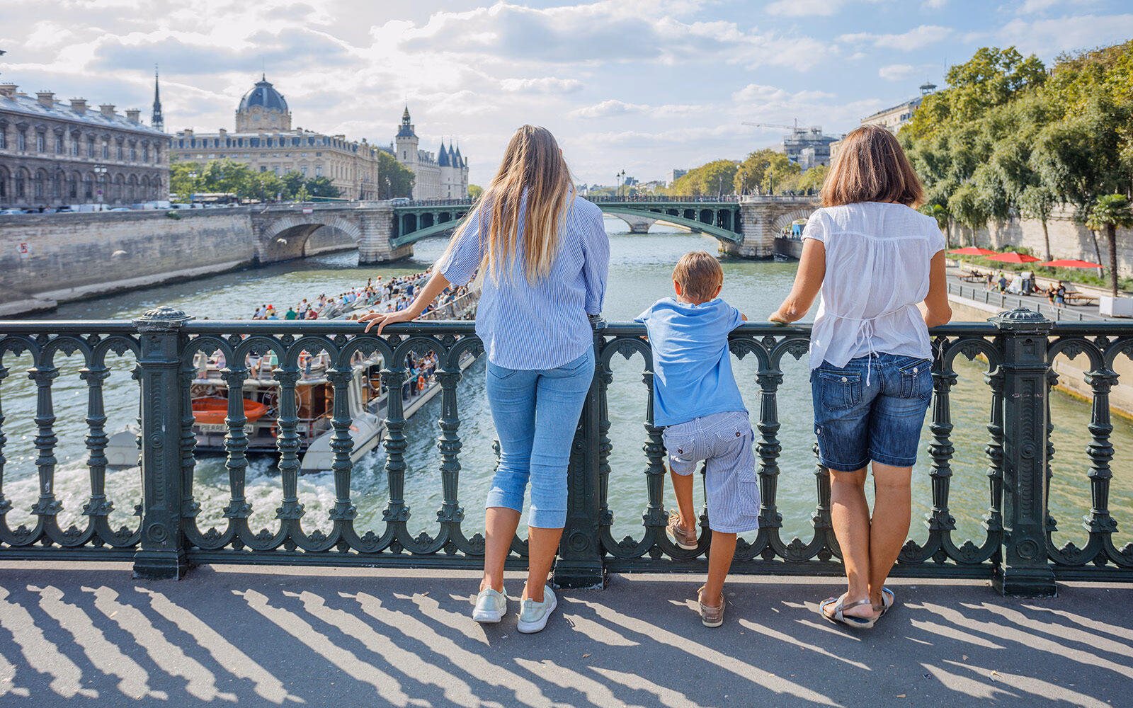 A family admires the view from a bridge over the Seine River in Paris.