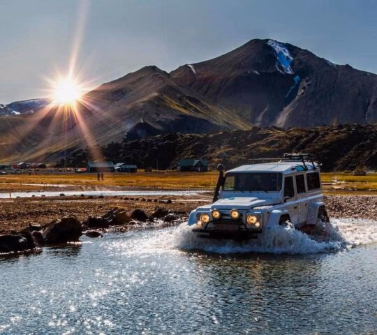 A modified Jeep driving through a river in Iceland