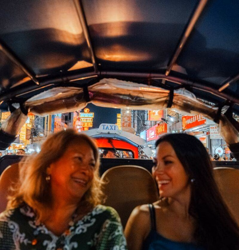A mother and daughter enjoy exploring Bangkok's Chinatown in a private tuk tuk experience.