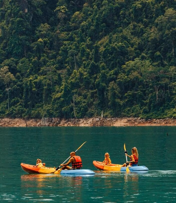 A family enjoy a kayaking activity in Cheow Lan Lake near Khao Sok National Park.