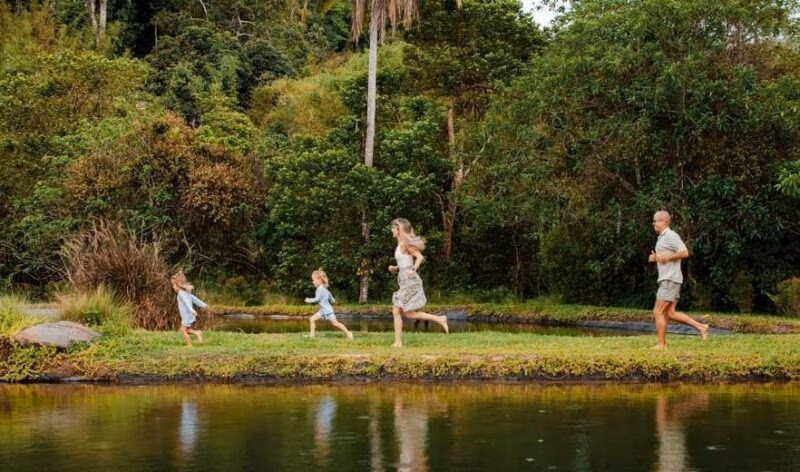 A family running in front of a small lake in Khao Sok national park.