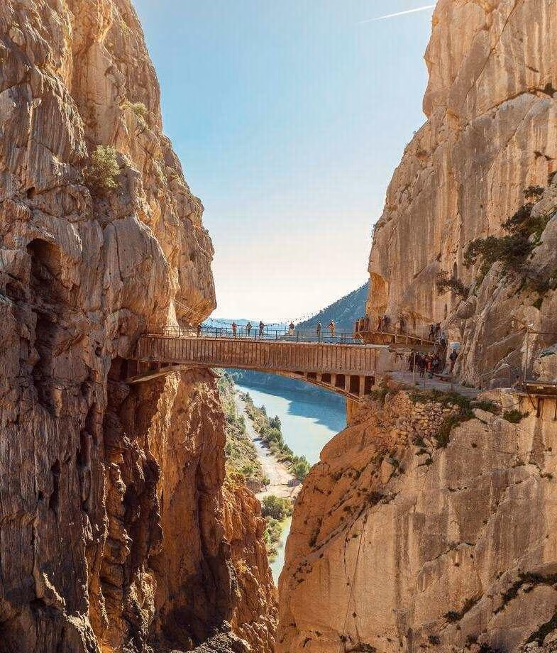 People crossing a wooden suspension bridge on Spain's Caminito del Rey hiking route