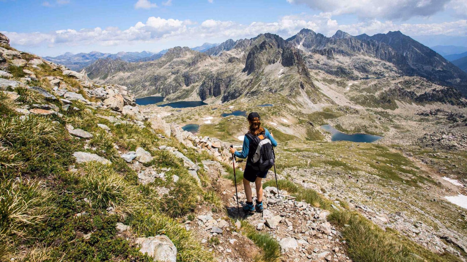 A woman hiking across mountainous landscapes in Sant Maurici National Park, Spain