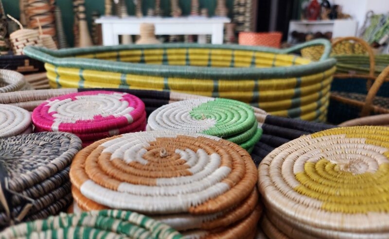 A close-up view of vibrant, coiled woven coasters stacked on a table displaying local crafts.