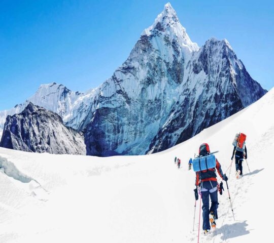 A group of climbers on snowy terrain ascending Mount Everest