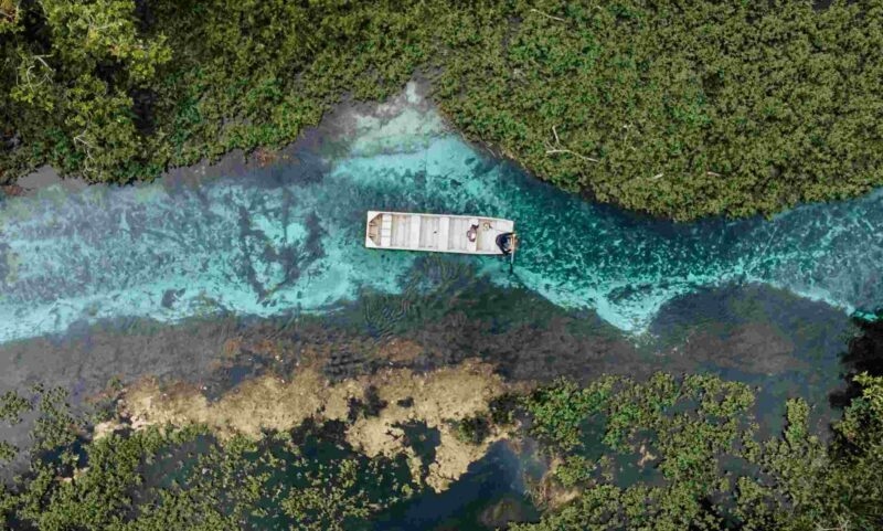 Aerial view of a small boat travelling along a river in Bonito, Brazil