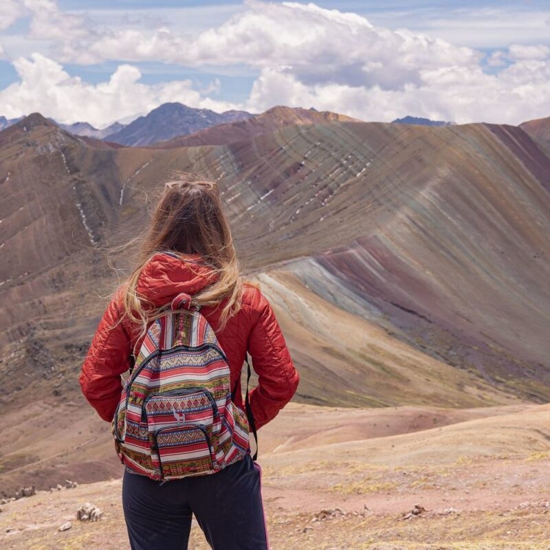 A woman standing in front of Peru's Rainbow Mountain