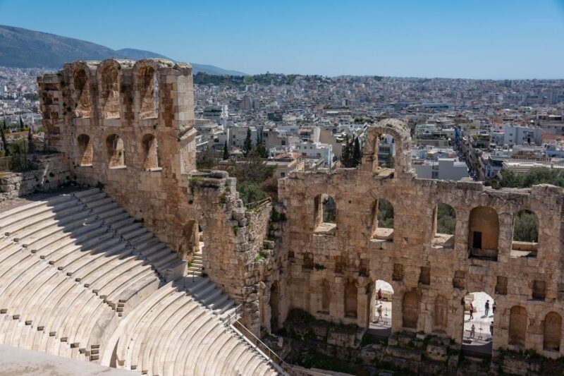 The Odeon of Herodes Atticus ancient stone theatre with its arches and tiered seating overlooking the city of Athens, Greece.