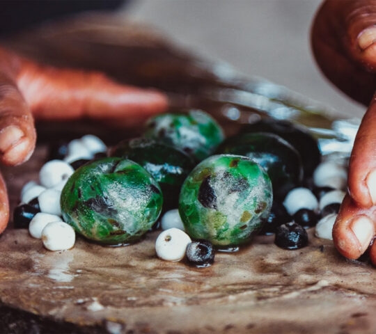 An artisan works with beads made from recycled glass.