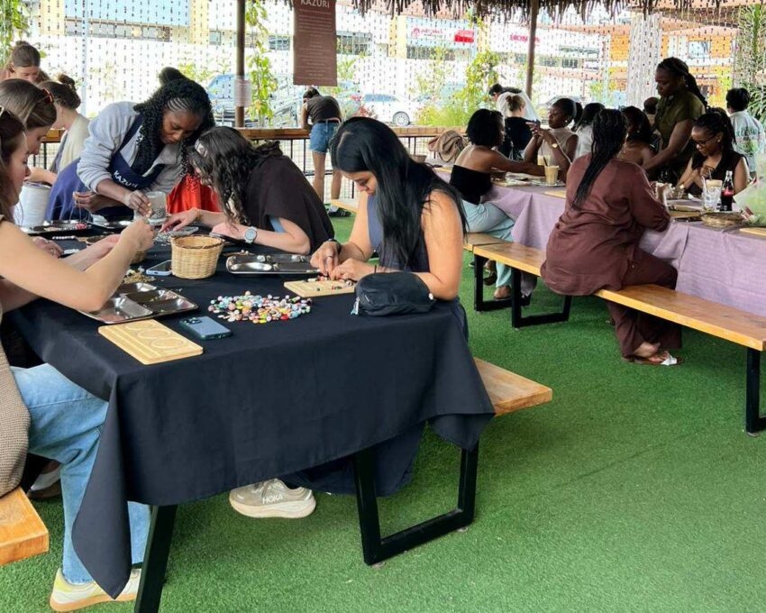 Women sat round a table making jewellery out of beads during a workshop at Kazuri beads in Nairobi