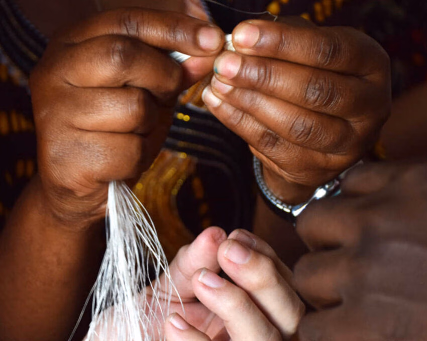 Close up a woman's hands holding thread during a beading workshop at the Nyamirambo Women's Centre in Kigali, Rwanda