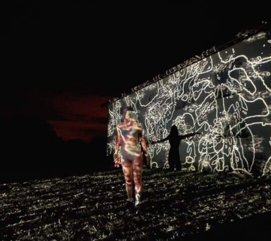 A multimedia art show with black and white projections on a large wall