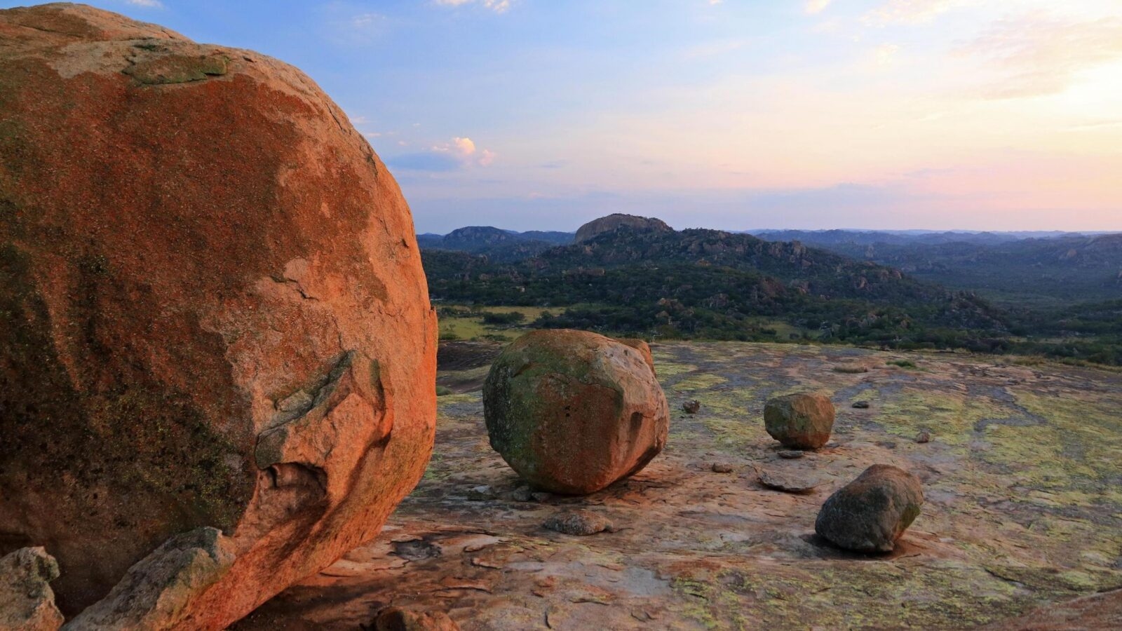Large boulders on a rocky outcrop at Cecil Rhodes grave, Matobo National Park, Zimbabwe, with hills in the background.