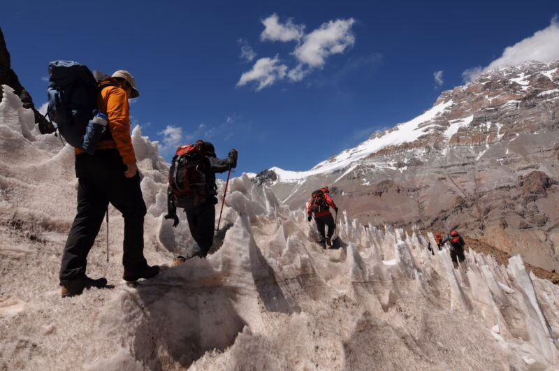 Three hikers traverse the Aconcagua Mountains