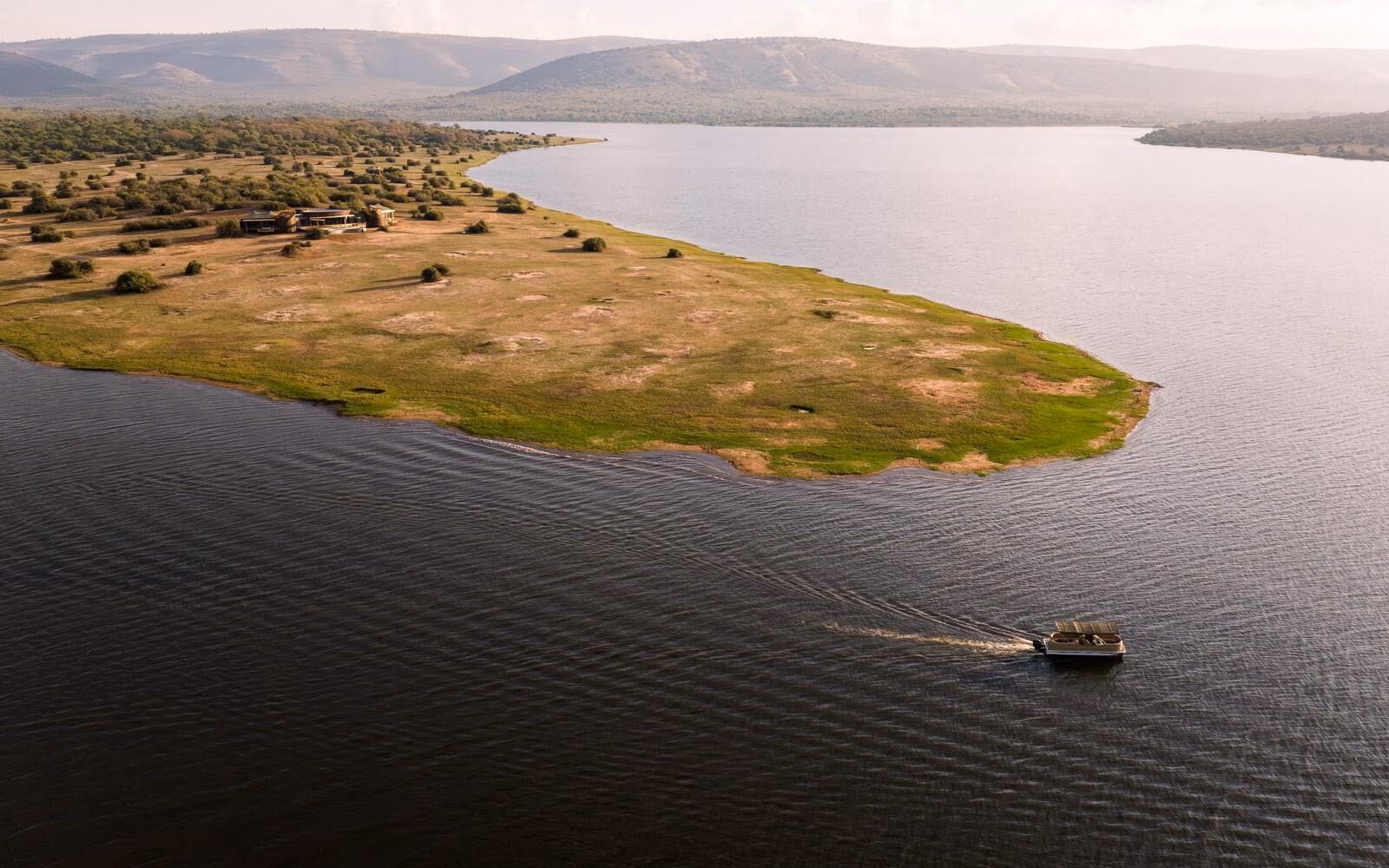 Cruise Lake Rwanyakazinga during your stay at Wilderness Magashi Peninsula, an intimate eight-guest retreat overlooking sweeping savannah and the distant Mutumba Mountains.