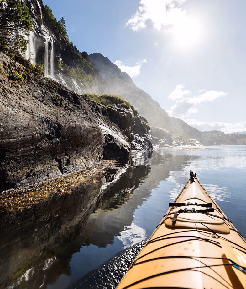 Kayak beneath cascading waterfalls in Norway’s Sunnfjord while staying at Åmot Gard. Enjoy the privacy of a secluded Finnish Arctic retreat, sharing coffee around an open fire amid snow-covered forests.