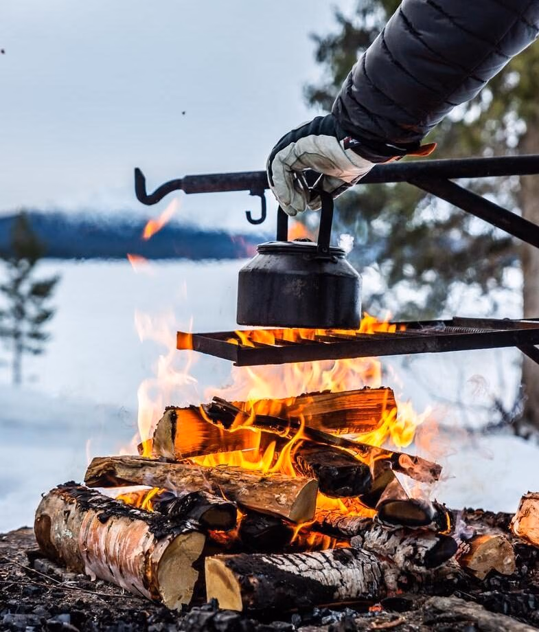 Kayak beneath cascading waterfalls in Norway’s Sunnfjord while staying at Åmot Gard. Enjoy the privacy of a secluded Finnish Arctic retreat, sharing coffee around an open fire amid snow-covered forests.