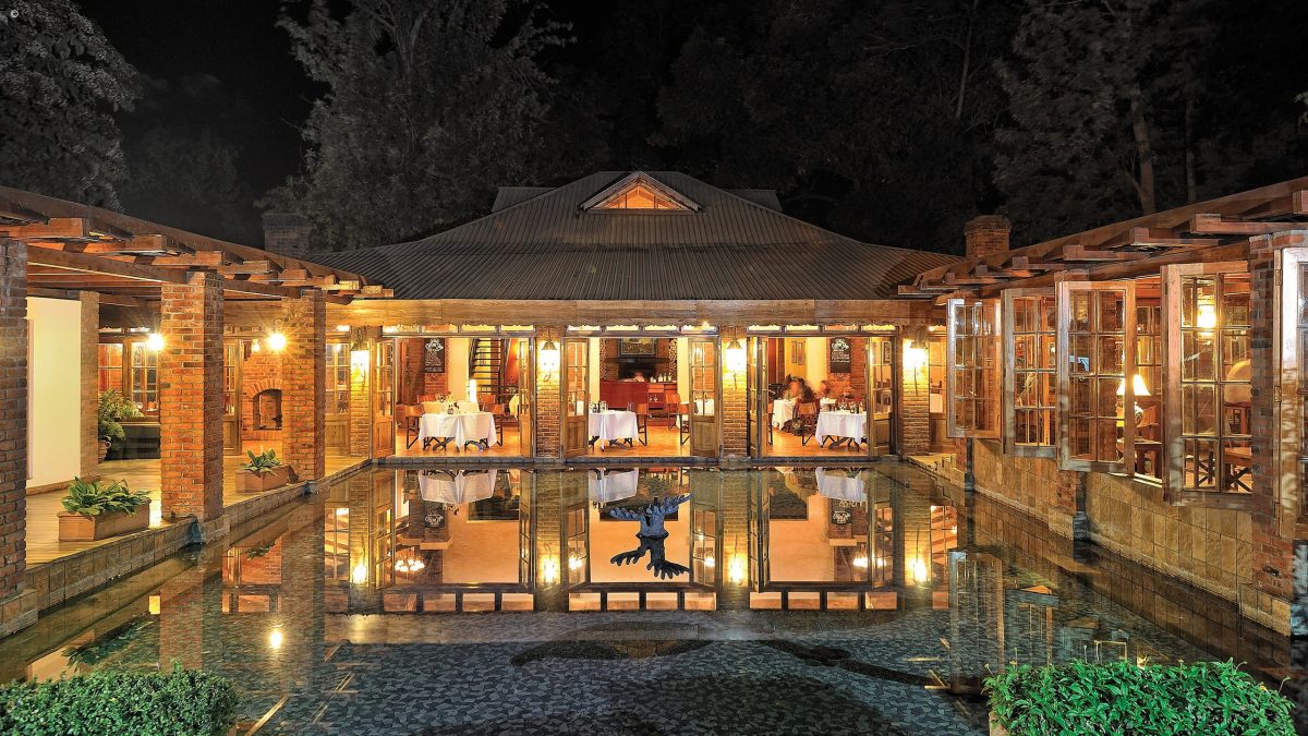 View of the dining room of Arusha Coffee Lodge from across the fountain at night, Arusha Tanzania