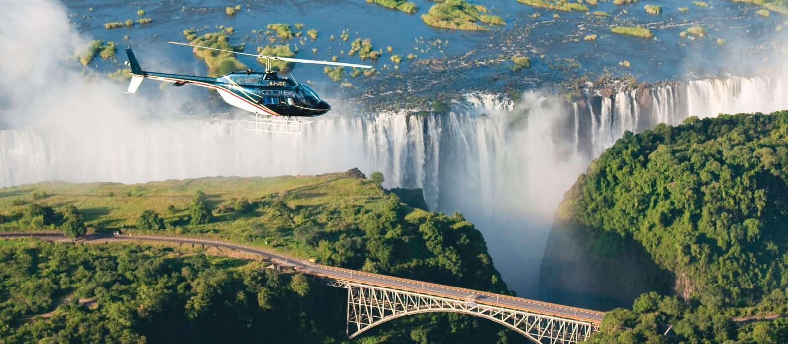 Aerial view of Victoria Falls Bridge at Victoria Falls, Livingstone with helicopter