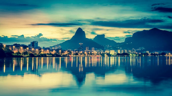 Sunset behind mountains in Rio de Janeiro with water reflection, Brazil