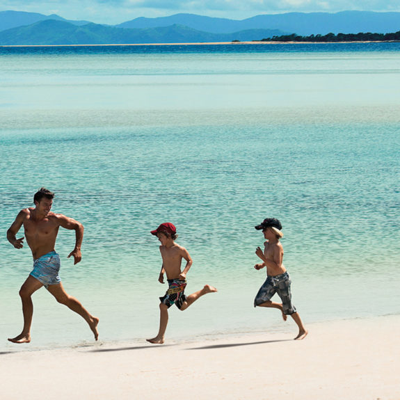 Family running along the beach, Hayman Island