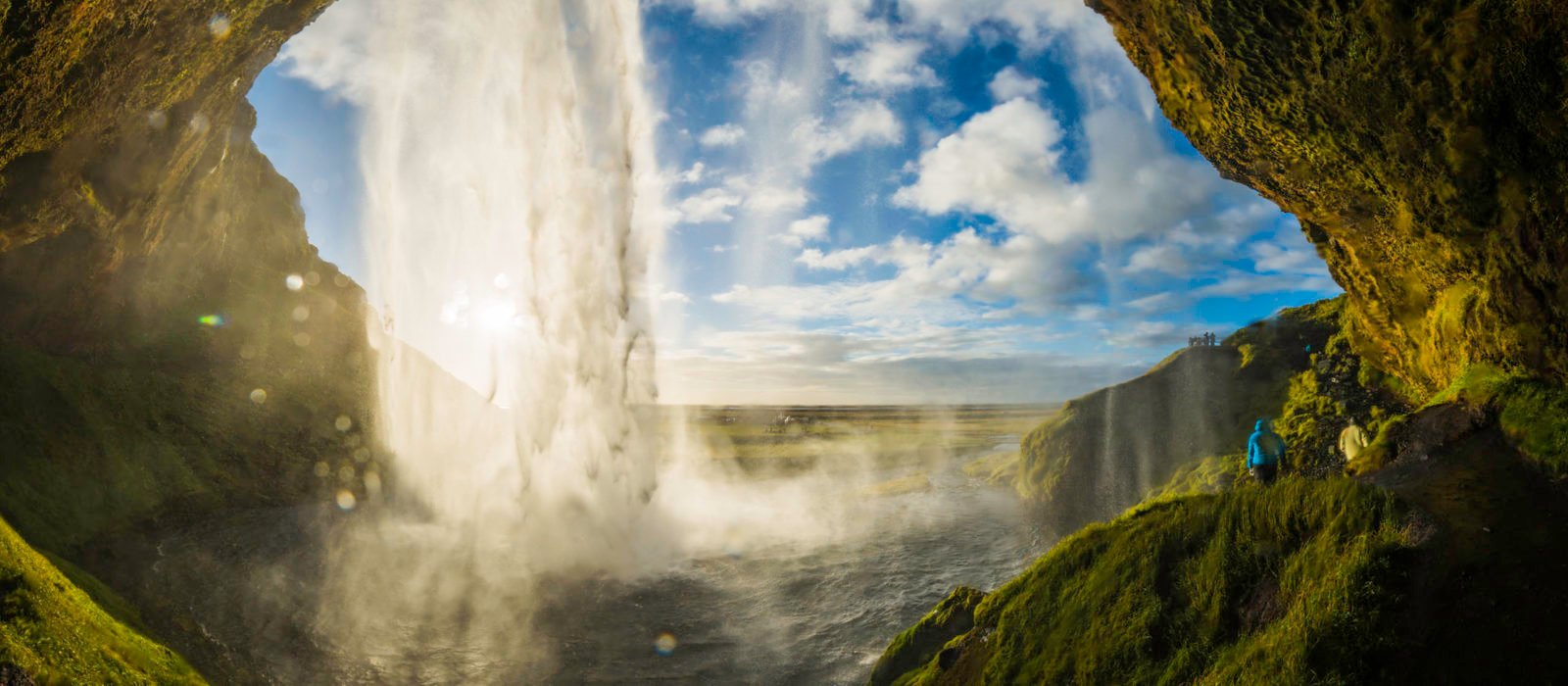 Waterfall tumbling into river above cavern mouth Seljalandsfoss Iceland