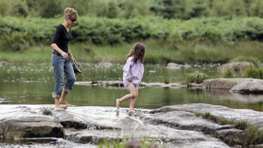 Mother and Daughter Crossing Beautiful Stream in Scotland