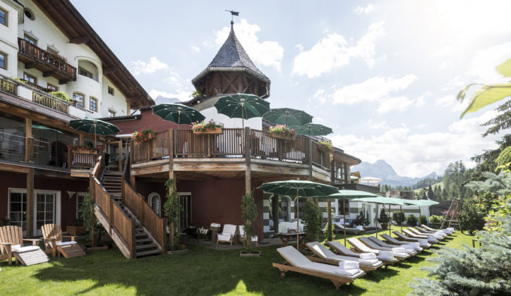 Exterior of Rosa Alpina, row of sun loungers on a summer's day, San Cassiano Italy