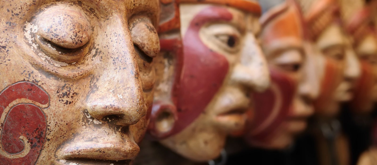 Close up of traditional Mayan clay masks at the Chichicastenango market in Guatemala