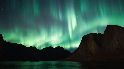Northern Lights and silhouettes of mountains in Norway
