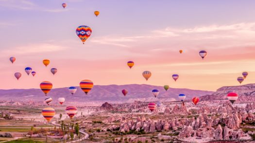 Hot air balloons dot the colourful sky above Cappadocia.