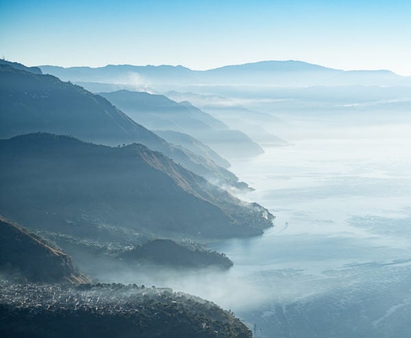 Aerial view of the mountains meeting Lake Atitlán in Guatemala at sunrise