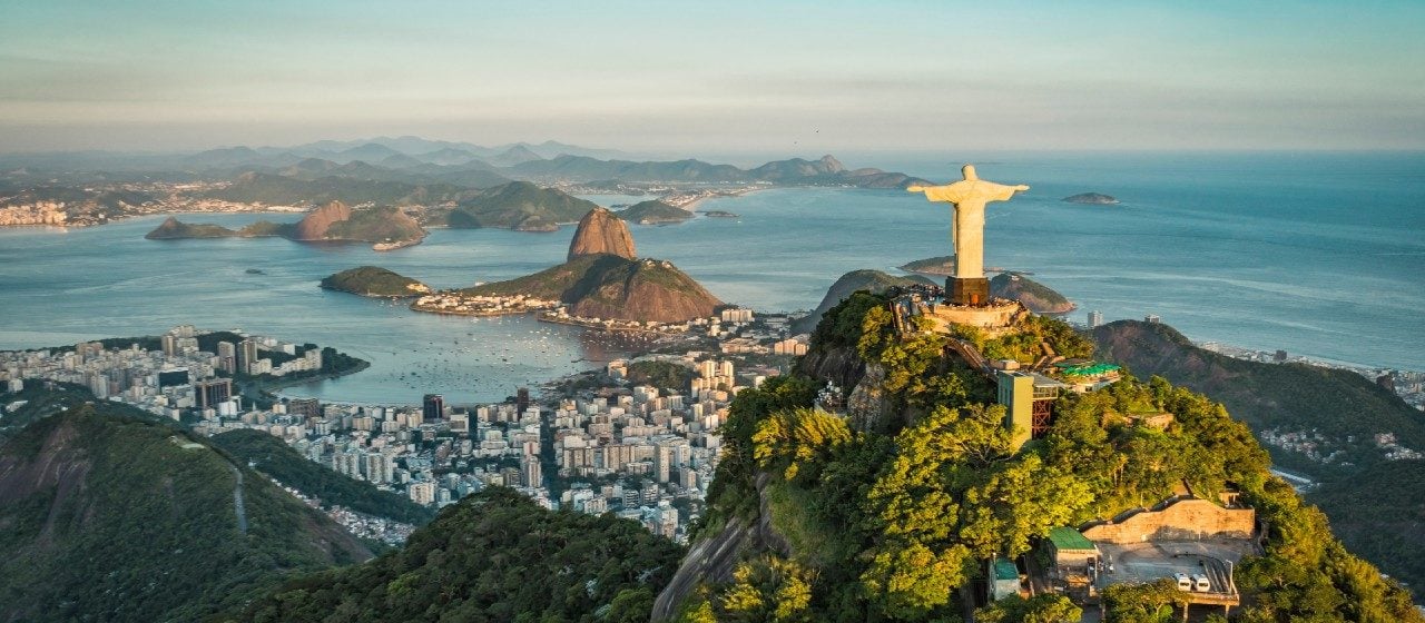 Panoramic of Christ the Redeemer, Rio de Janeiro, at golden hour set against the city and Guanabara Bay