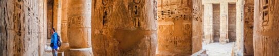 A tourist examines the hieroglyphs on the walls of the temple of Medinet Habu, Luxor, Egypt