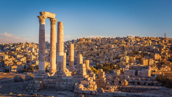 Ruins of a temple with blue skies and Amman city, Jordan, behind