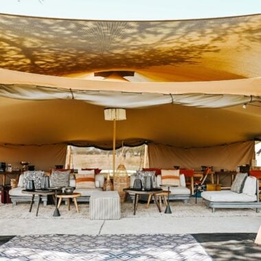 Open lounge of luxury safari camp Wilderness Usawa, with sunlight and sofas