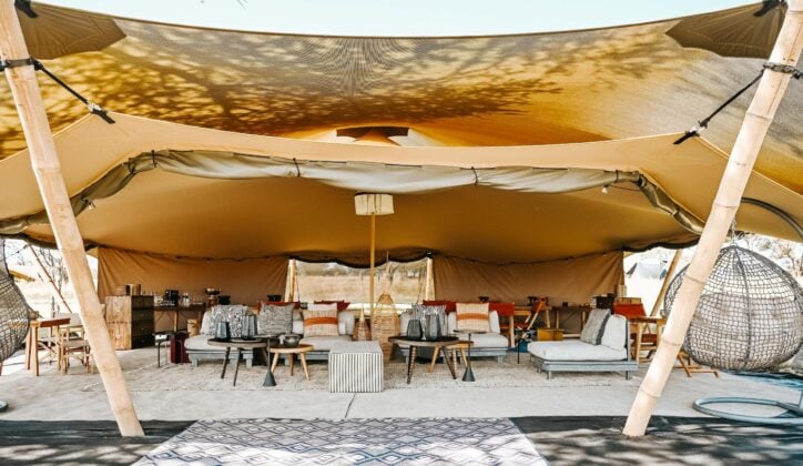 Open lounge of luxury safari camp Wilderness Usawa, with sunlight and sofas